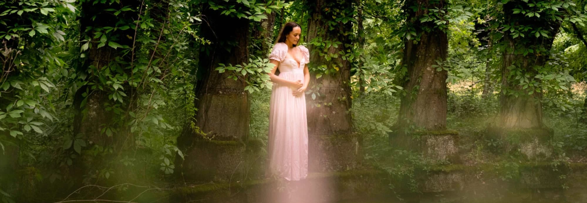 Dakota in a rose gown among enchanted woodland