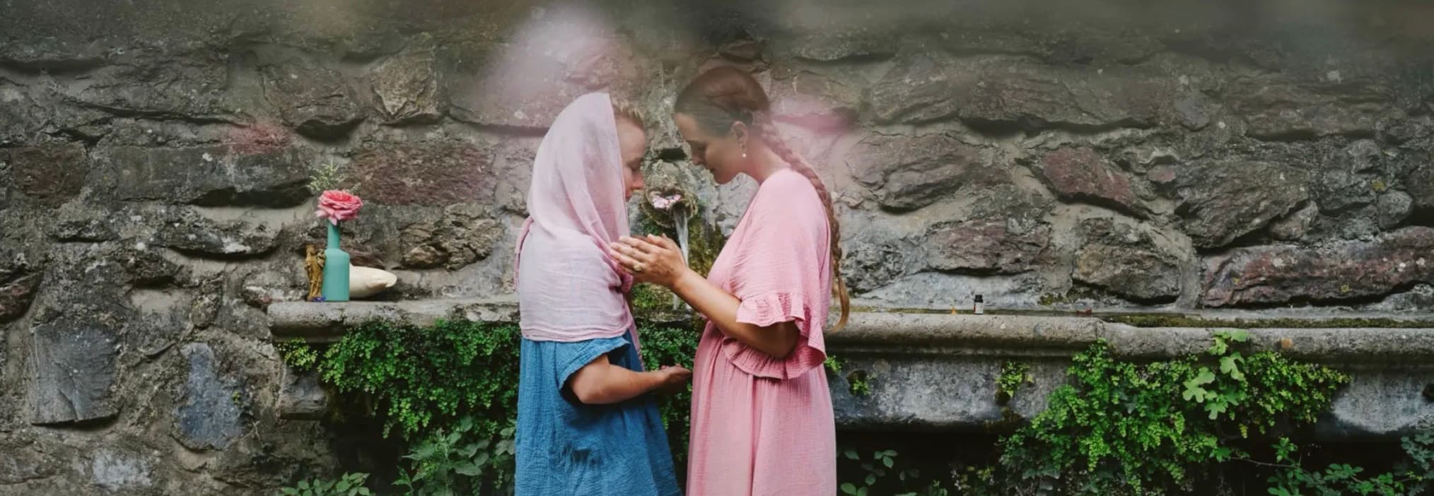 Two women in ceremony at a sacred spring in France
